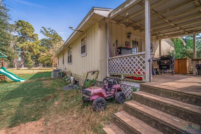 view of side of home with cooling unit and a yard