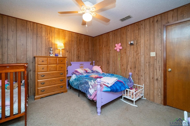 bedroom featuring carpet, ceiling fan, and wooden walls