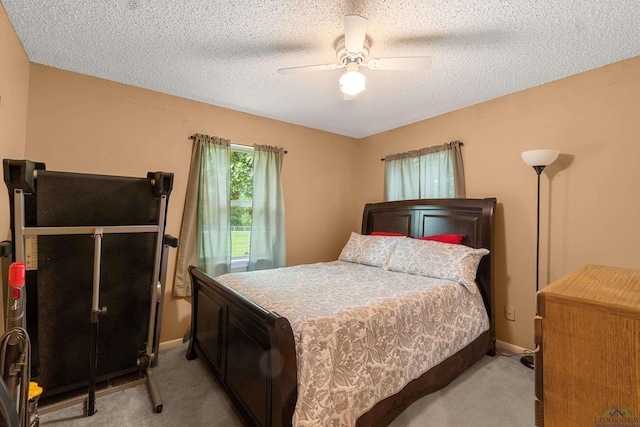 bedroom featuring ceiling fan, light carpet, and a textured ceiling