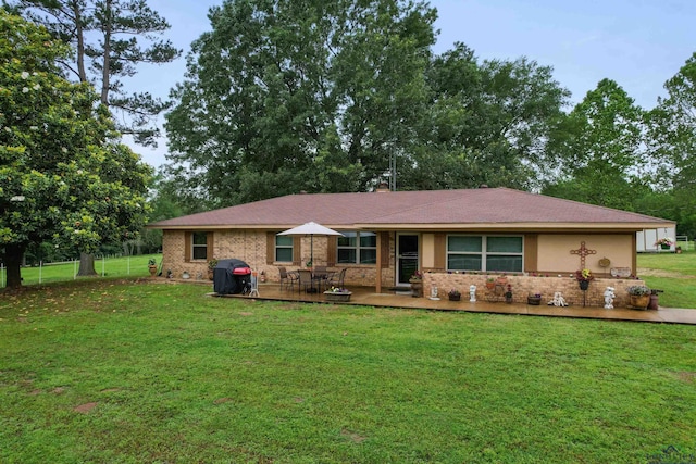 ranch-style home featuring a front lawn and a patio area