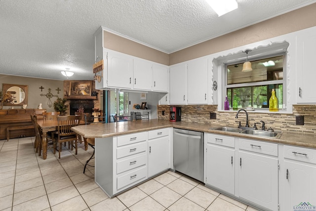 kitchen featuring kitchen peninsula, stainless steel dishwasher, a wealth of natural light, sink, and white cabinetry