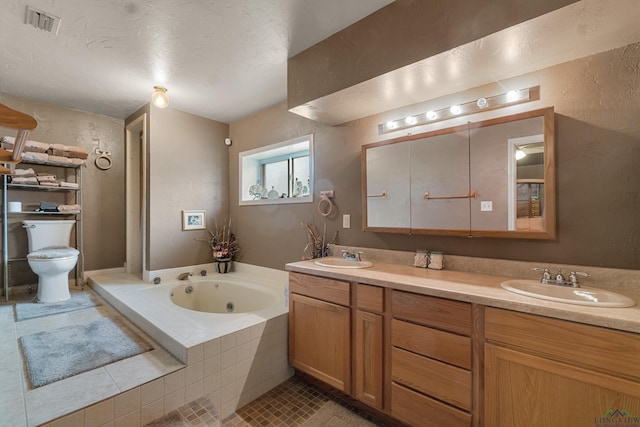 bathroom with vanity, tile patterned floors, toilet, a textured ceiling, and tiled bath