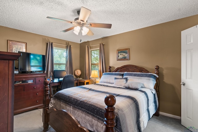 bedroom featuring a textured ceiling, ceiling fan, and light carpet