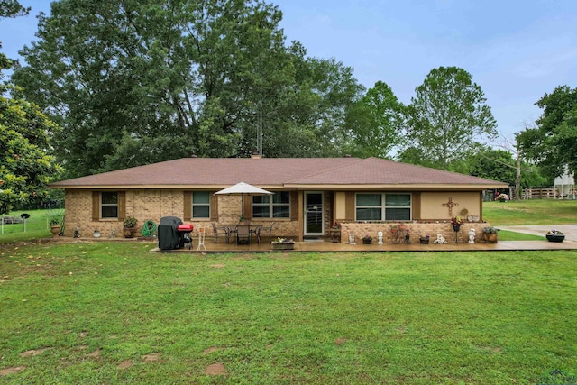 ranch-style house featuring a front yard and a patio area