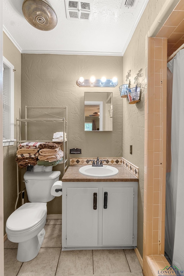 bathroom with vanity, toilet, ornamental molding, a textured ceiling, and curtained shower