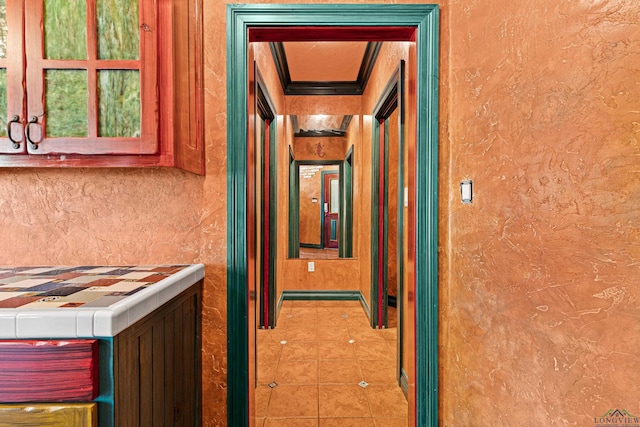 corridor with tile patterned flooring and ornamental molding