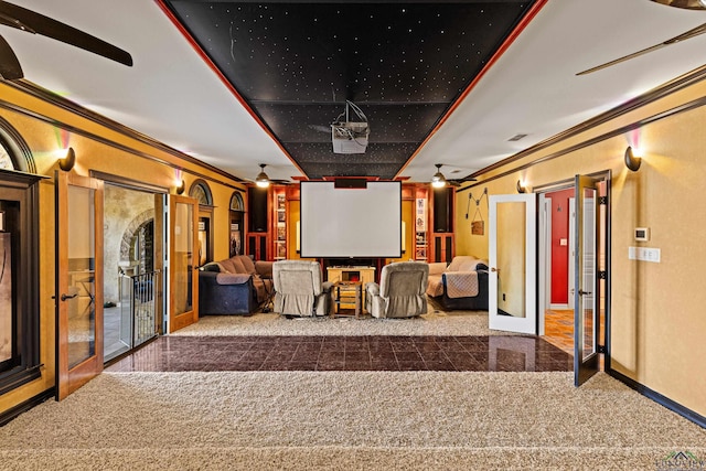 cinema room featuring crown molding, french doors, carpet, and ceiling fan