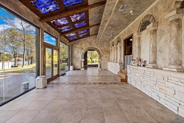 unfurnished sunroom featuring ornate columns and french doors