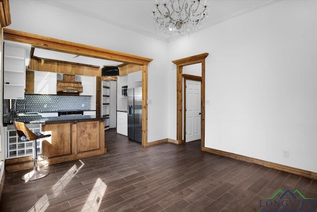 501 S Harrison St, Longview, TX 75601 - kitchen with appliances with stainless steel finishes, dark countertops, baseboards, dark wood-style flooring, and a chandelier