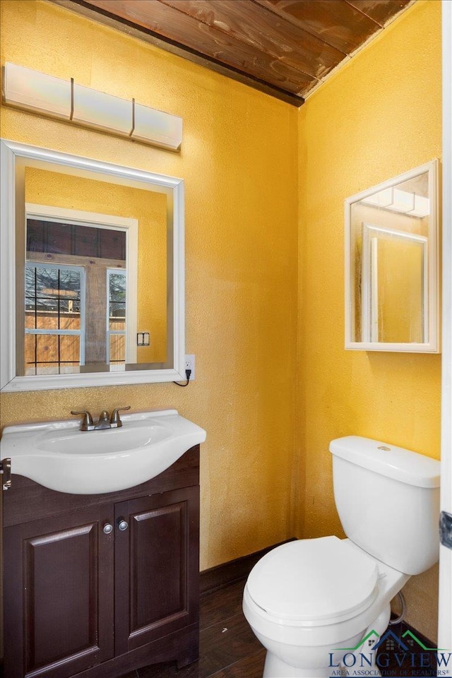 501 S Harrison St, Longview, TX 75601 - half bathroom featuring toilet, vanity, and wood finished floors