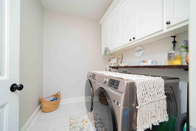 clothes washing area featuring baseboards, cabinet space, washer and clothes dryer, and tile patterned floors