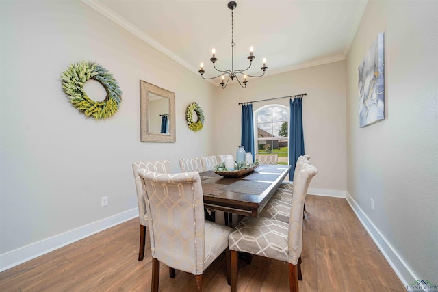 dining area featuring an inviting chandelier, ornamental molding, and wood finished floors