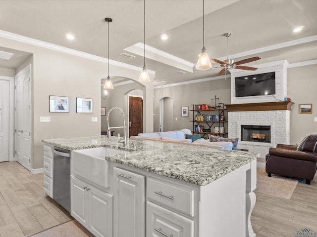 kitchen featuring pendant lighting, sink, white cabinets, stainless steel dishwasher, and ceiling fan