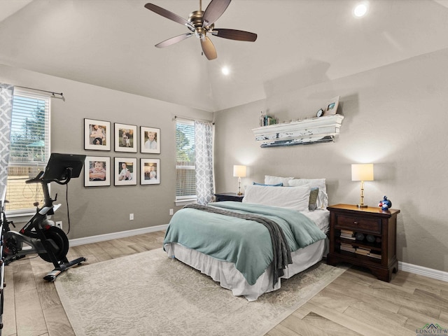 bedroom with multiple windows, light hardwood / wood-style flooring, ceiling fan, and vaulted ceiling