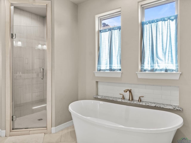 bathroom with tile patterned floors and shower with separate bathtub