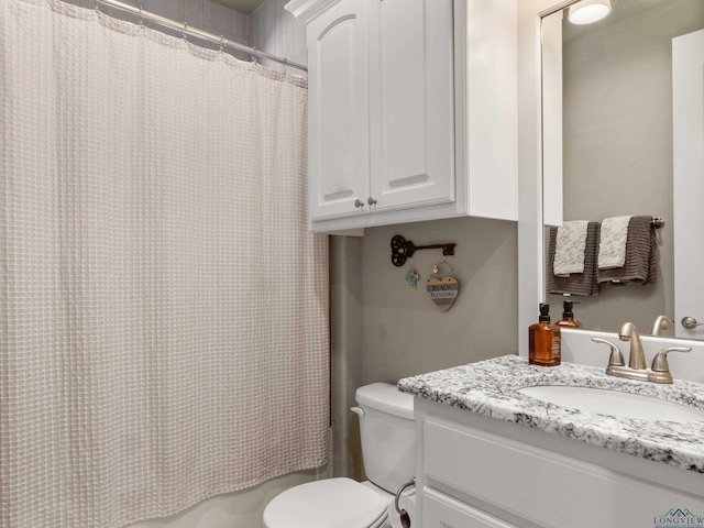 bathroom featuring vanity, curtained shower, and toilet