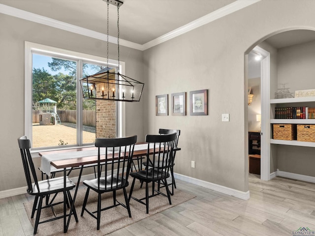 dining room with ornamental molding and light hardwood / wood-style flooring