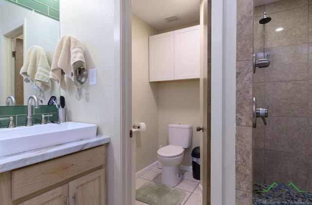 bathroom with tile patterned floors, toilet, vanity, and tiled shower