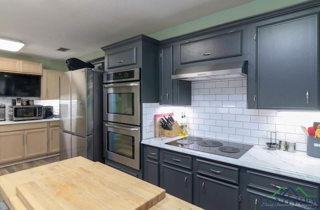 kitchen featuring backsplash, gray cabinets, stainless steel appliances, and hardwood / wood-style flooring