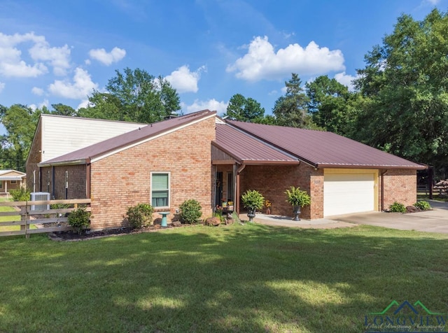 ranch-style home featuring a garage, a front yard, and cooling unit