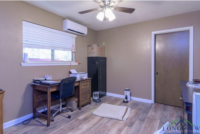 home office featuring light wood-type flooring, ceiling fan, and an AC wall unit