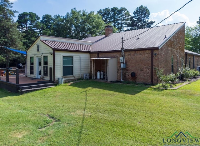 rear view of house with a deck and a yard