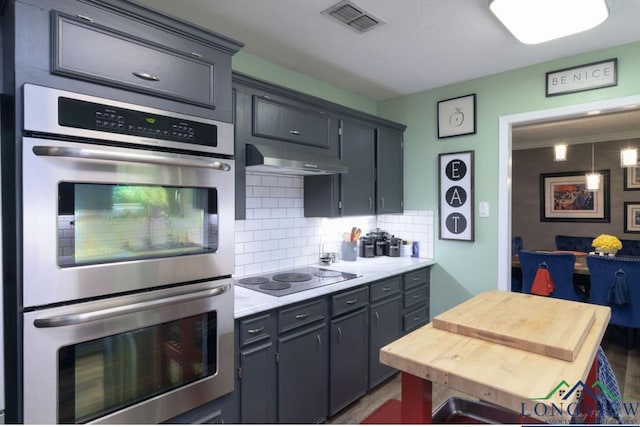 kitchen featuring black electric stovetop, double oven, gray cabinetry, and tasteful backsplash