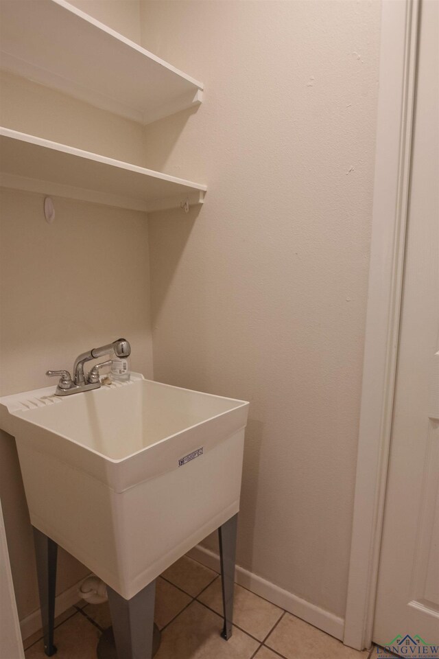 1302 Jeff Davis Dr, Tyler, TX 75703 - laundry room featuring baseboards and light tile patterned flooring