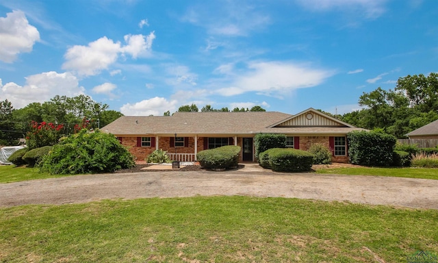1302 Jeff Davis Dr, Tyler, TX 75703 - ranch-style home with a front lawn, brick siding, and curved driveway