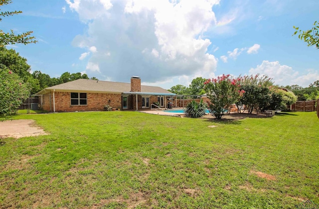 1302 Jeff Davis Dr, Tyler, TX 75703 - back of house with a chimney, a fenced backyard, brick siding, and a patio area