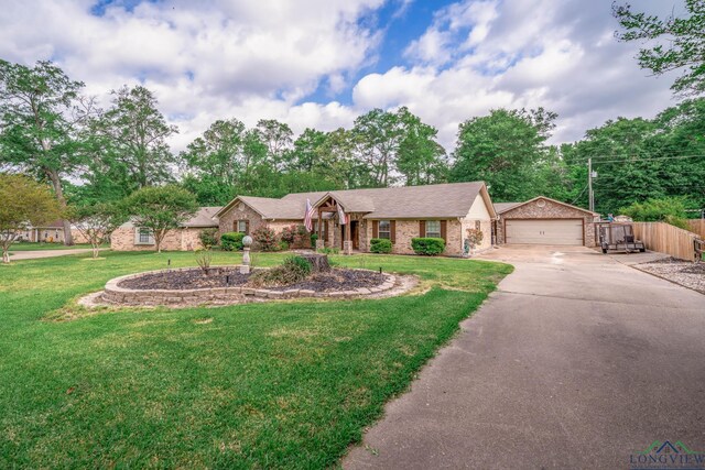 1901 Azalea St, Gilmer, TX 75644 - view of front of home with a front lawn, driveway, an outdoor structure, fence, and brick siding
