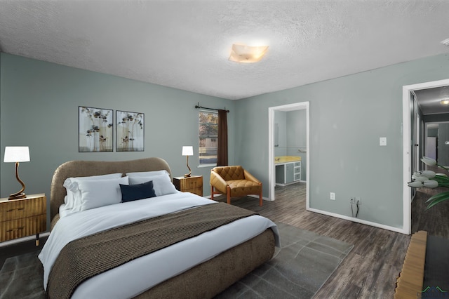 bedroom featuring dark hardwood / wood-style floors, a textured ceiling, and ensuite bath