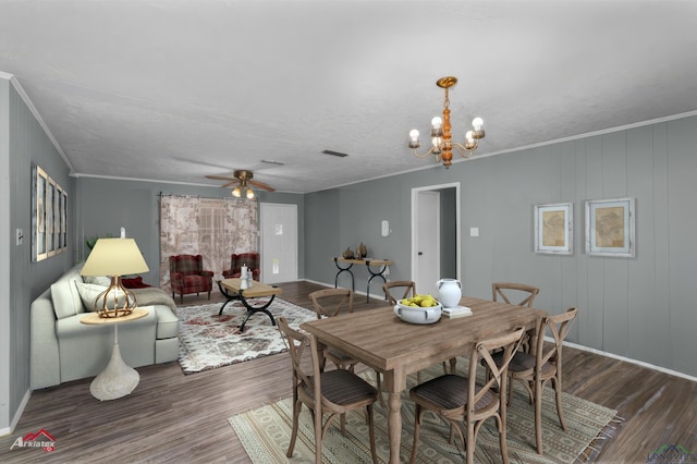 dining area featuring a textured ceiling, ceiling fan with notable chandelier, dark hardwood / wood-style flooring, and crown molding