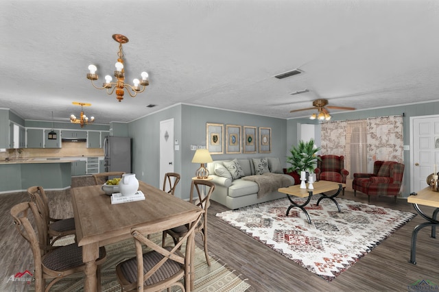 interior space featuring a textured ceiling, dark hardwood / wood-style floors, ceiling fan with notable chandelier, and ornamental molding