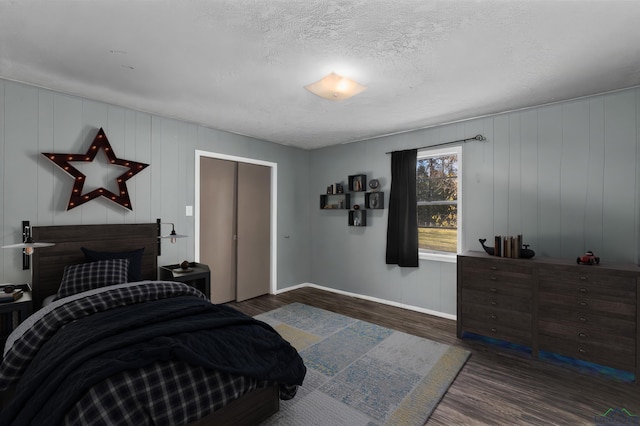 bedroom with a textured ceiling and dark wood-type flooring