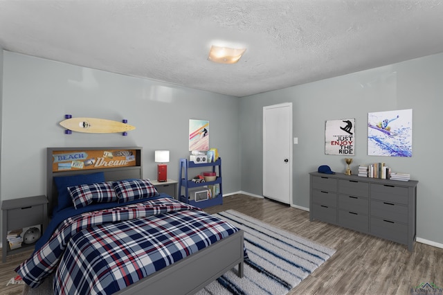 bedroom with hardwood / wood-style floors and a textured ceiling