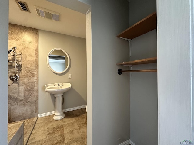 587 Floyd Evans Rd, Marshall, TX 75672 - full bathroom featuring visible vents, tiled shower, and baseboards