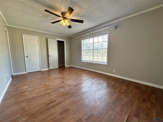 587 Floyd Evans Rd, Marshall, TX 75672 - unfurnished bedroom with a textured ceiling, crown molding, baseboards, and wood finished floors