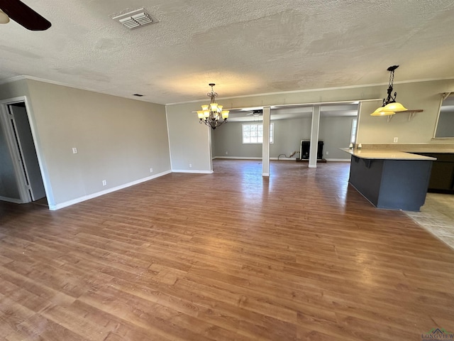 587 Floyd Evans Rd, Marshall, TX 75672 - unfurnished living room with baseboards, visible vents, light wood-style flooring, a textured ceiling, and crown molding