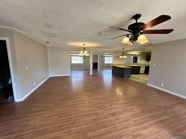 587 Floyd Evans Rd, Marshall, TX 75672 - unfurnished living room featuring ceiling fan with notable chandelier, wood finished floors, visible vents, and baseboards