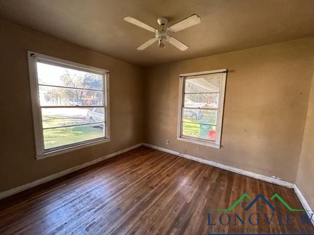 spare room with ceiling fan and dark hardwood / wood-style flooring