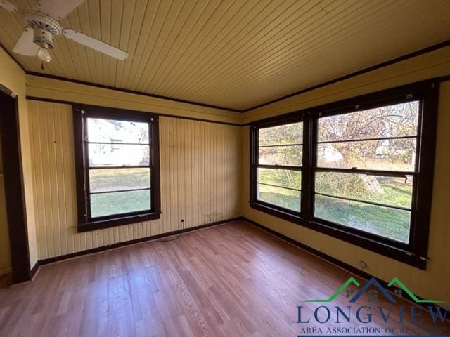 empty room with hardwood / wood-style floors, ceiling fan, and wood ceiling