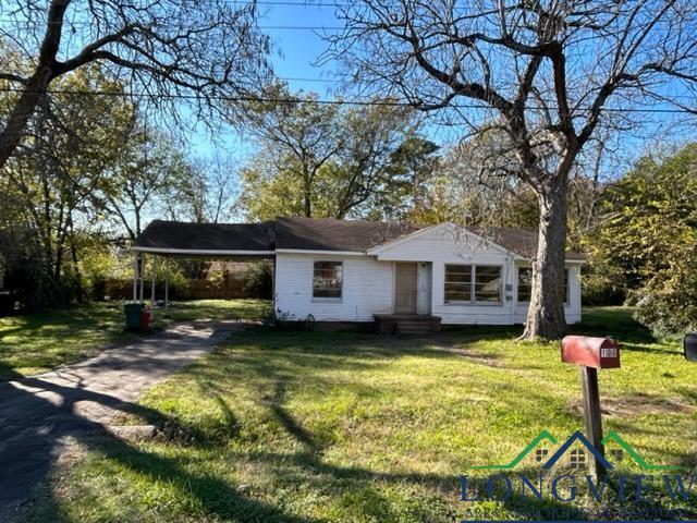 ranch-style house with a front yard and a carport