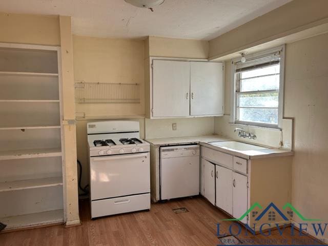 kitchen with white appliances, light hardwood / wood-style flooring, white cabinetry, and sink