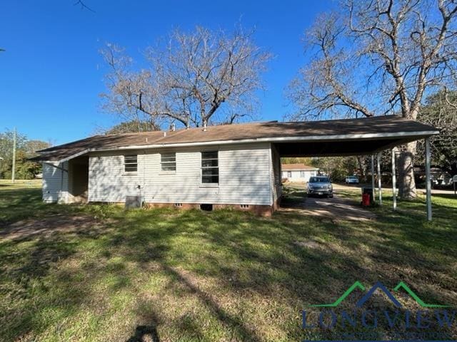 rear view of house featuring a yard and a carport