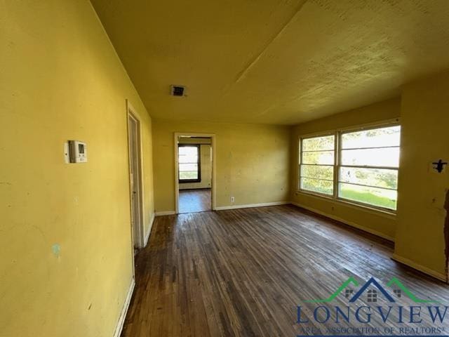 unfurnished room with dark wood-type flooring