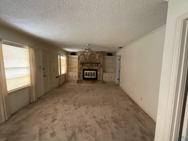 unfurnished living room featuring a textured ceiling, light colored carpet, a stone fireplace, and ceiling fan