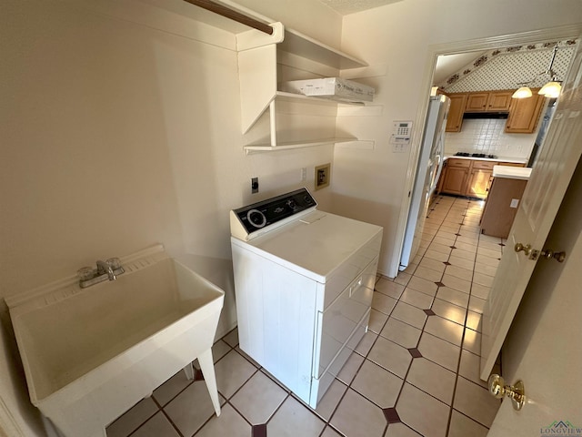 clothes washing area featuring light tile patterned flooring, washer / dryer, and sink