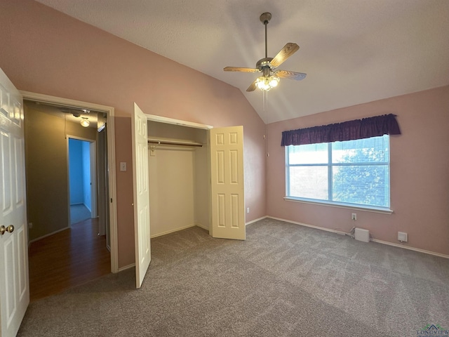 unfurnished bedroom featuring lofted ceiling, carpet flooring, ceiling fan, and a closet