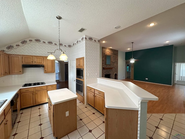 kitchen with pendant lighting, vaulted ceiling, black appliances, and a kitchen island